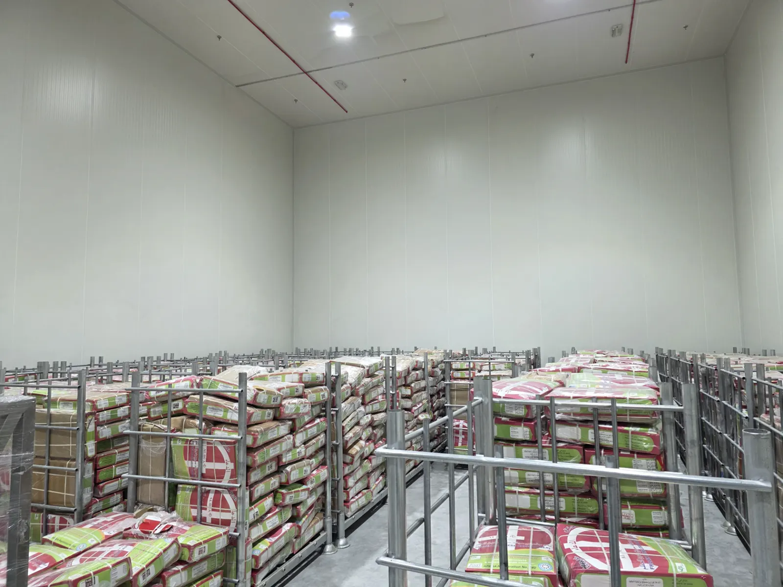 Frozen halal meat cartons on steel pallet cages inside the LAHM PURE Dubai cold store